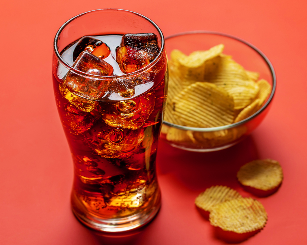 Refresco de cola con unas patatas fritas.